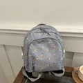 Hellblauer Blumen-Rucksack mit verstellbaren Trägern auf einem hölzernen Tisch - Blau
