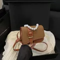 Orangefarbene Umhängetasche mit brauner Webklappe und elegantem Perlenhandgriff - Braun