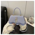 Light blue crossbody bag with wavy bottom, golden S logo, and metallic fringe detail - Blue