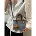 Retro denim bucket bag with brown leather trim and a cute puppy charm shown on model - Black and Khaki