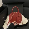 Dark red shell-shaped handbag with small coin purse and golden metal hardware - Red