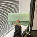 Pochette minimalista verde chiaro con texture orizzontale e fibbia in metallo dorato - Verde