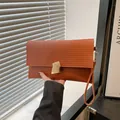 Pleated brown orange clutch bag with geometric gold metal buckle and hand strap - Brown