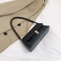 Minimalistische schwarze Baguette-Schultertasche aus Kunstleder mit goldener Metallschnalle - Schwarz