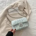 Lichtblauwe gewatteerde schoudertas met zilveren ketting en ronde draaisluiting - Blauw