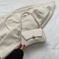Elegant cream white baguette bag with gold buckle and unique knotted strap detail - White