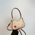Borsa hobo color crema testurizzata con toppe a cuore e cinturini in pelle marrone - Marrone