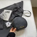 Black round crossbody bag with woven texture, golden lettering, and white cat plush charm - With Charm / Black