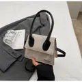 Chic light gray square handbag with black handles on a stylish blazer background - Khaki