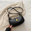 Bolso de hombro negro tipo media luna con hebilla dorada triangular y correa de cuero - Negro