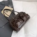 Glossy coffee brown underarm bag featuring front bow pockets and sleek leather finish - Brown