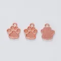Detailed macro view of rose gold bear paw pendants showing front and back texture - Rose Gold