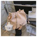 Pink suede bucket bag with gold chain strap and plush lamb charm accessory - With Plush Charm / Pink