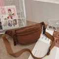 Brown corduroy waist bag with striped texture and woven zipper pull on a casual rug - Brown