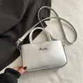 Mini borsa quadrata argento minimalista con tracolla e finitura metallica lucida - Argento