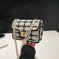 Elegante zwart-witte tweed crossbodytas met gouden ketting en vierkante draaisluiting - Wit