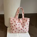 Détail du sac fourre-tout en velours côtelé rose avec broderies de fraises rouges - Rose