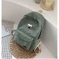 Green corduroy backpack for students featuring cartoon eyes and cherry embroidery - Light Green