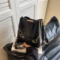 Elegante borsa a secchiello nera con catena dorata e tracolla ampia a motivi - Nero