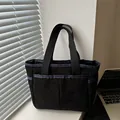 Black corduroy tote bag with double front pockets and sturdy woven handles for daily use - Black