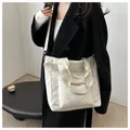 Detail of cream large tote bag with front flap pocket and adjustable nylon strap - White