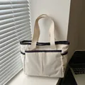 Beige corduroy tote bag with navy blue trim and front pockets for daily commute - White