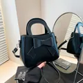 Elegante bolso de mano negro con lazo, asas resistentes y detalles metálicos dorados - Negro