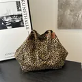 Grand sac cabas en toile imprimé léopard avec rivets métalliques sur bois sombre - Marron