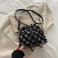 Fashionable black and white tweed bucket bag with tassel details and long leather strap - Black Grid