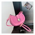 Chic pink saddle bag with a large gold heart buckle and adjustable strap for women - Pink