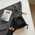 Schwarze Kordelzug-Beuteltasche mit Vintage-Textur und goldener Kette - Schwarz