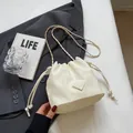 Elegante cremeweiße Tunnelzug-Beuteltasche mit Kettenriemen und Metall-Logo-Plakette - Gebrochenes Weiß