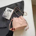 Schicke rosa Wildleder-Beuteltasche mit Kettenriemen und modischem Dreieckslogo - Rosa