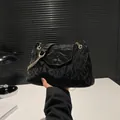 Minimalistische schwarze Tasche mit Faltenstruktur und goldener Gliederkette - Schwarz