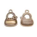 Detailed close-up of vintage bronze alloy handbag charms with floral patterns and textures - Antique Bronze