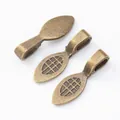 Detailed view of three vintage bronze glue-on bails with cross-hatch texture on white background - Antique Bronze