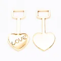 Detail of vintage gold heart-shaped pendants with LOVE engraving and rectangular metal loops - Antique Gold