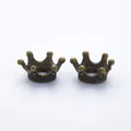 Detailed macro view of two vintage bronze alloy crown charms for DIY jewelry making - One Size / Antique Bronze