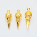 Detailed view of vintage gold bird skull pendants with ornate baroque carvings - Gold