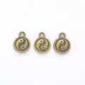 Three vintage bronze Yin Yang charms for DIY jewelry making on white background - Antique Bronze