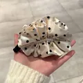 Détail de la barrette à nœud crème avec pois noirs, perles blanches et pendentif doré - Pois Beige