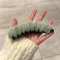 Gros plan d'une pince banane en peluche vert clair montrant la fourrure et les dents - Vert Peluche