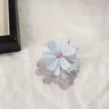 Dettaglio di un fermaglio per capelli a fiore in tessuto viola con eleganti perline - Celeste