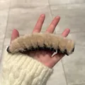 Close-up of a plush light brown banana hair clip with sturdy black plastic teeth - Beige Plush