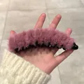 Soft pink plush banana hair clip in hand showing fluffy texture and secure grip - Rose Red