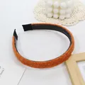 Detail view of orange knit headband featuring non-slip teeth and soft fabric texture - Orange