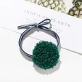 Dettaglio di un elastico per capelli in peluche verde scuro con fiocco a righe blu - Verde