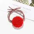 Dettaglio dell'elastico per capelli con pompon rosso soffice e fiocco su sfondo bianco - Rosso