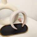 Detail view of thickened beige PU leather headband on a decorative black gold tray - Beige