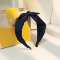 Elegant navy blue fabric headband with knotted bow design for a minimalist hair style - Navy Blue